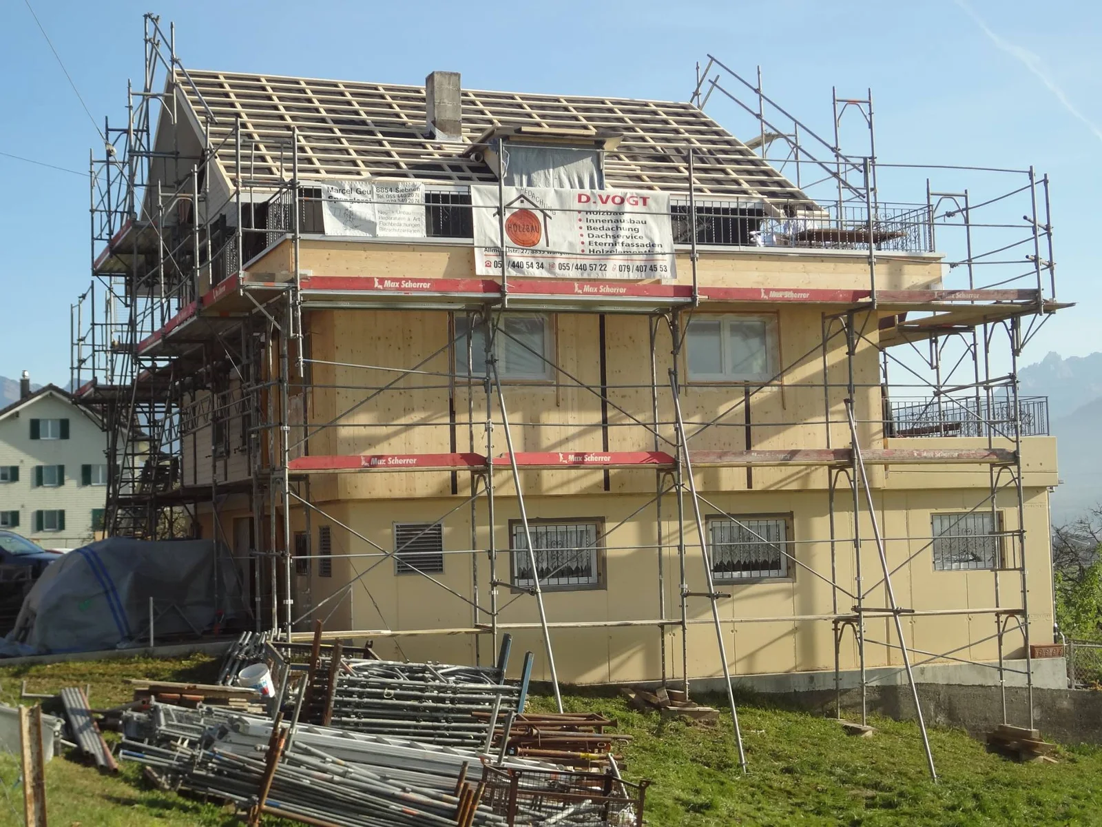 Sanierung eines Wohnhauses mit neuer Holzfassade und neuem Dach, eingerüstet