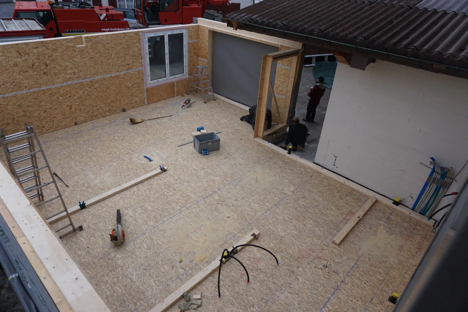 Montage von Holzelementen: Bodenplatte und Wandelemente mit eingebautem Fenster