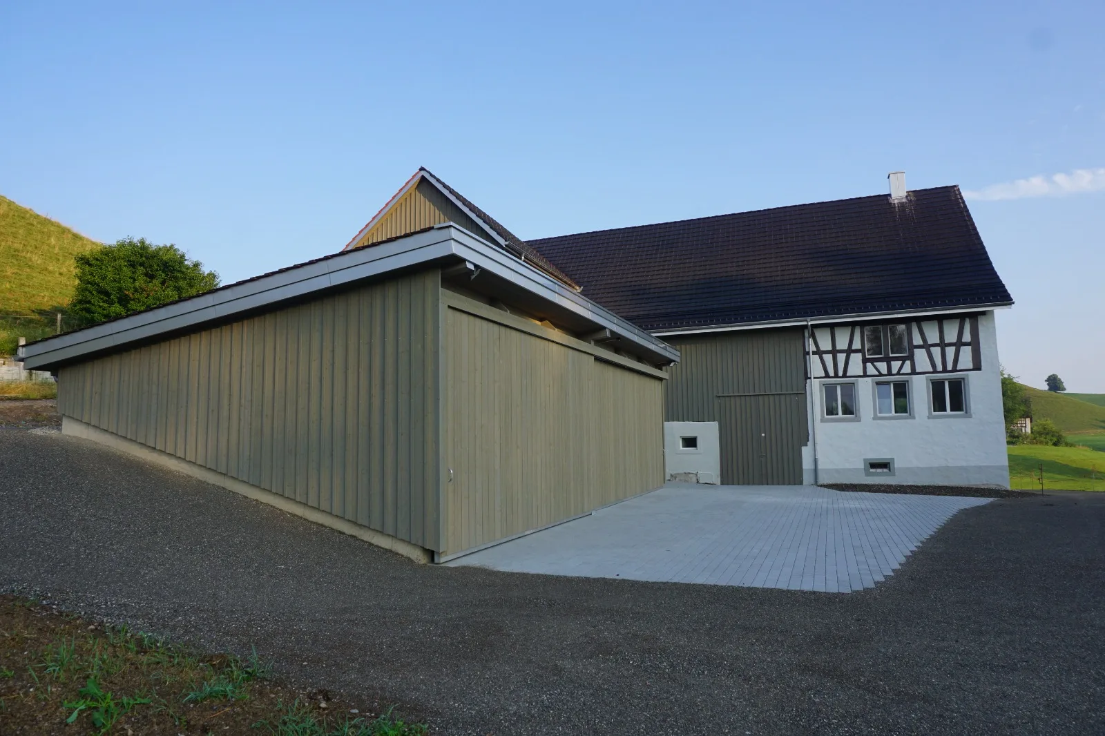 Neuer Anbau mit Holzschalung und Pultdach am sanierten Bauernhaus