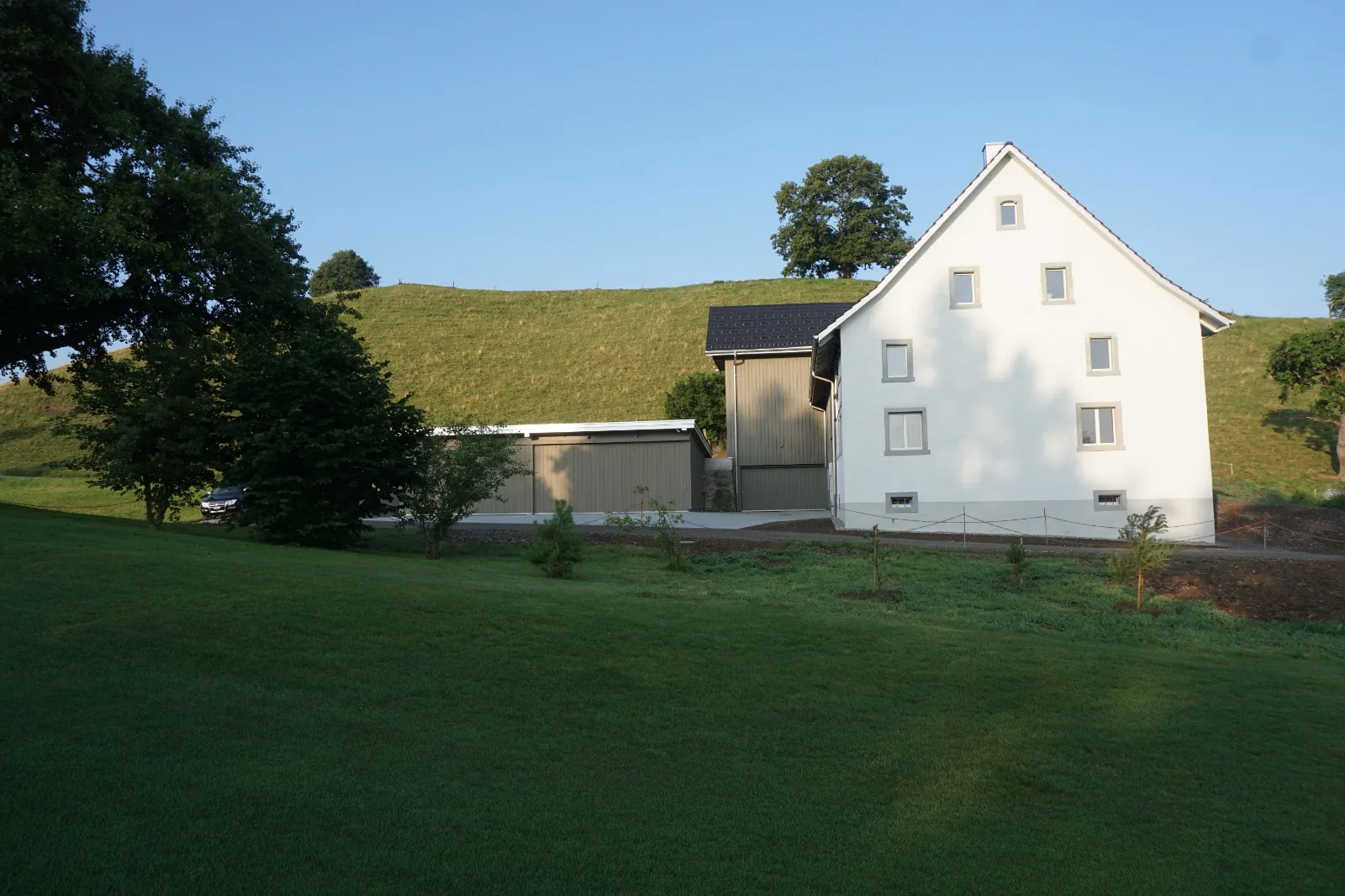 Saniertes Bauernhaus mit weisser Giebelfassade in der Landschaft
